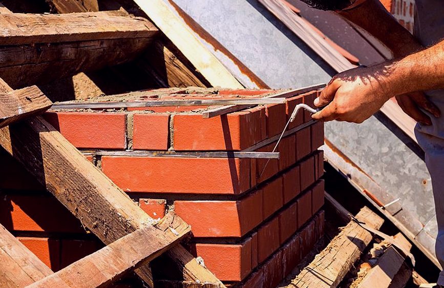 Brick seated into a fresh mortar bed on a Corona rebuild